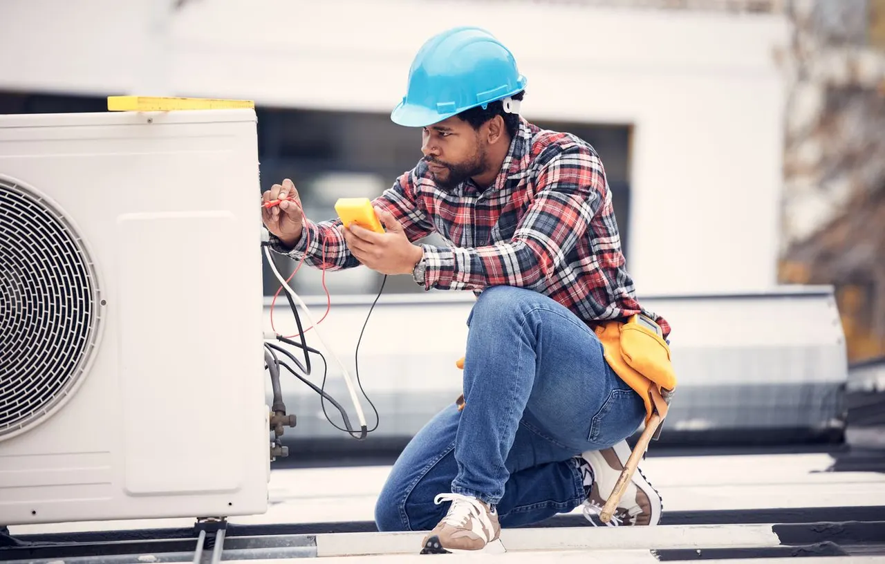 HVAC technician performing late-summer AC repairs at a home in Pompano Beach, Florida.