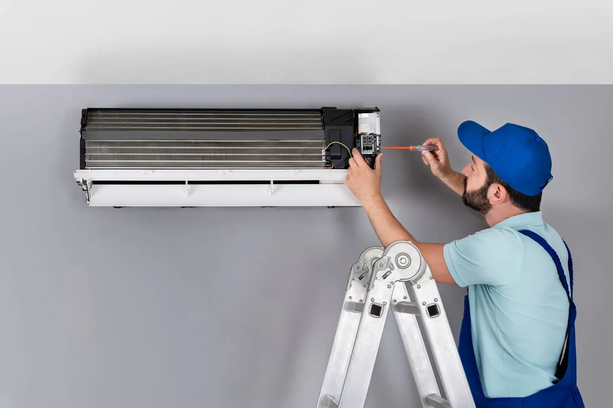 HVAC technician performing routine AC maintenance for membership plan in Fort Lauderdale Florida.